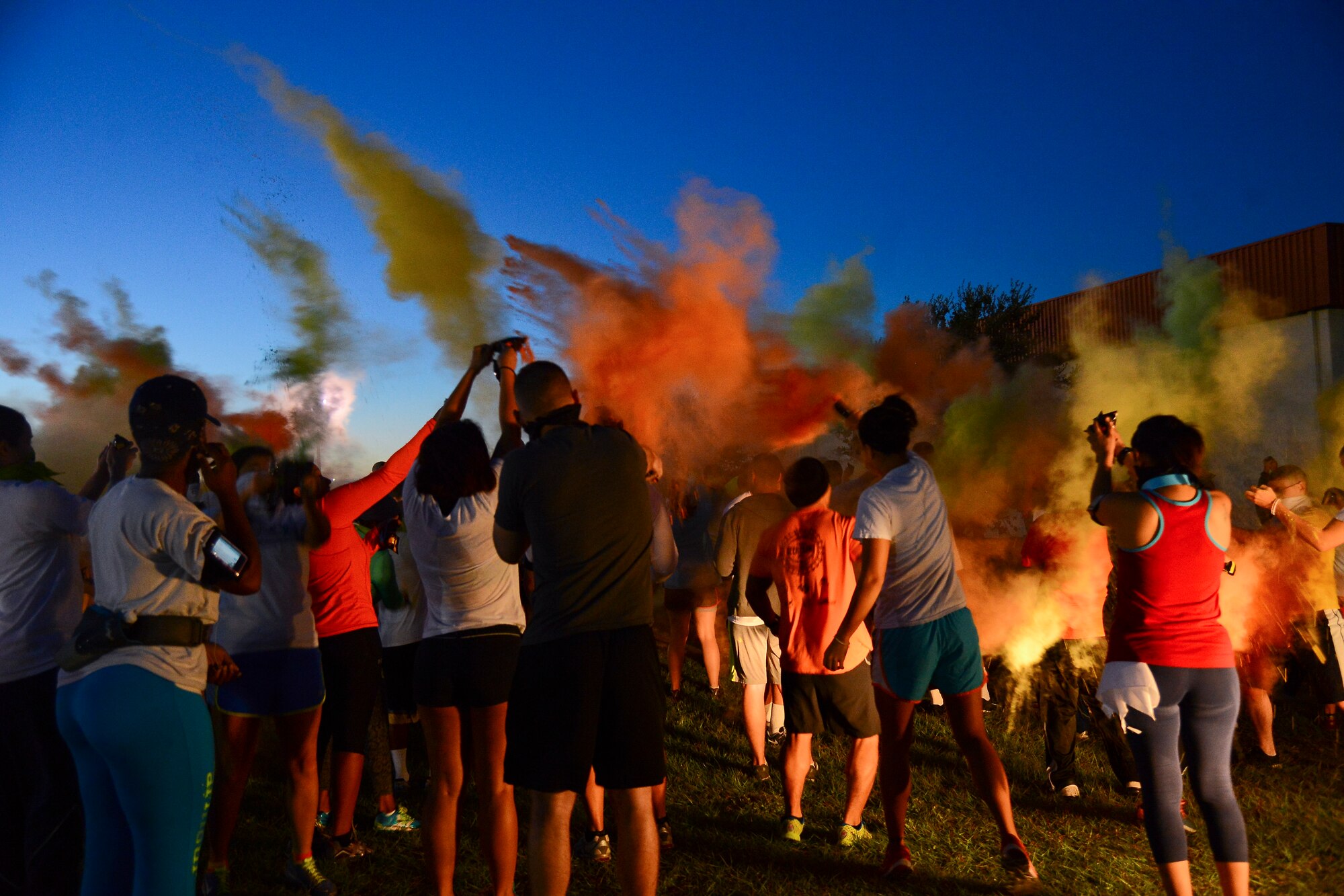 A crowd of participants burst open their color powder packets before the beginning of the “Paint the Pumpkin” 5K color run at MacDill Air Force Base, Fla., Oct. 24, 2014. Each runner was issued a white t-shirt, three color powder packets, and a festive bandana before the race.  (U.S. Air Force photo by Airman 1st Class Danielle Conde/Released)