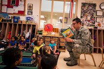 U.S. Air Force Senior Airman Julian Broaddus, 23d Civil Engineer Squadron engineering journeyman, reads a book to children at the Child Development Center II Oct. 28, 2014, at Moody Air Force Base, Ga. Because October is Energy Action Month, the CES held various events to educate Airmen and their families on how to make more energy-efficient choices. (U.S. Air Force photo by Senior Airman Olivia Bumpers/Released)