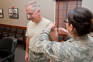 U.S. Air Force Col. John J. Allen Jr., 633rd Air Base Wing commander, receives a flu shot from Senior Airman Lavette Atkins, 633rd Medical Operations Squadron immunizations technician at Langley Air Force Base, Va., Oct. 23, 2014. Vaccination venues for active-duty military members and beneficiaries are being held until Oct. 31. For specific details, call the Immunizations clinic at 764-6985. (U.S. Air Force photo by Staff Sgt. Stephanie R. Plichta/Released)