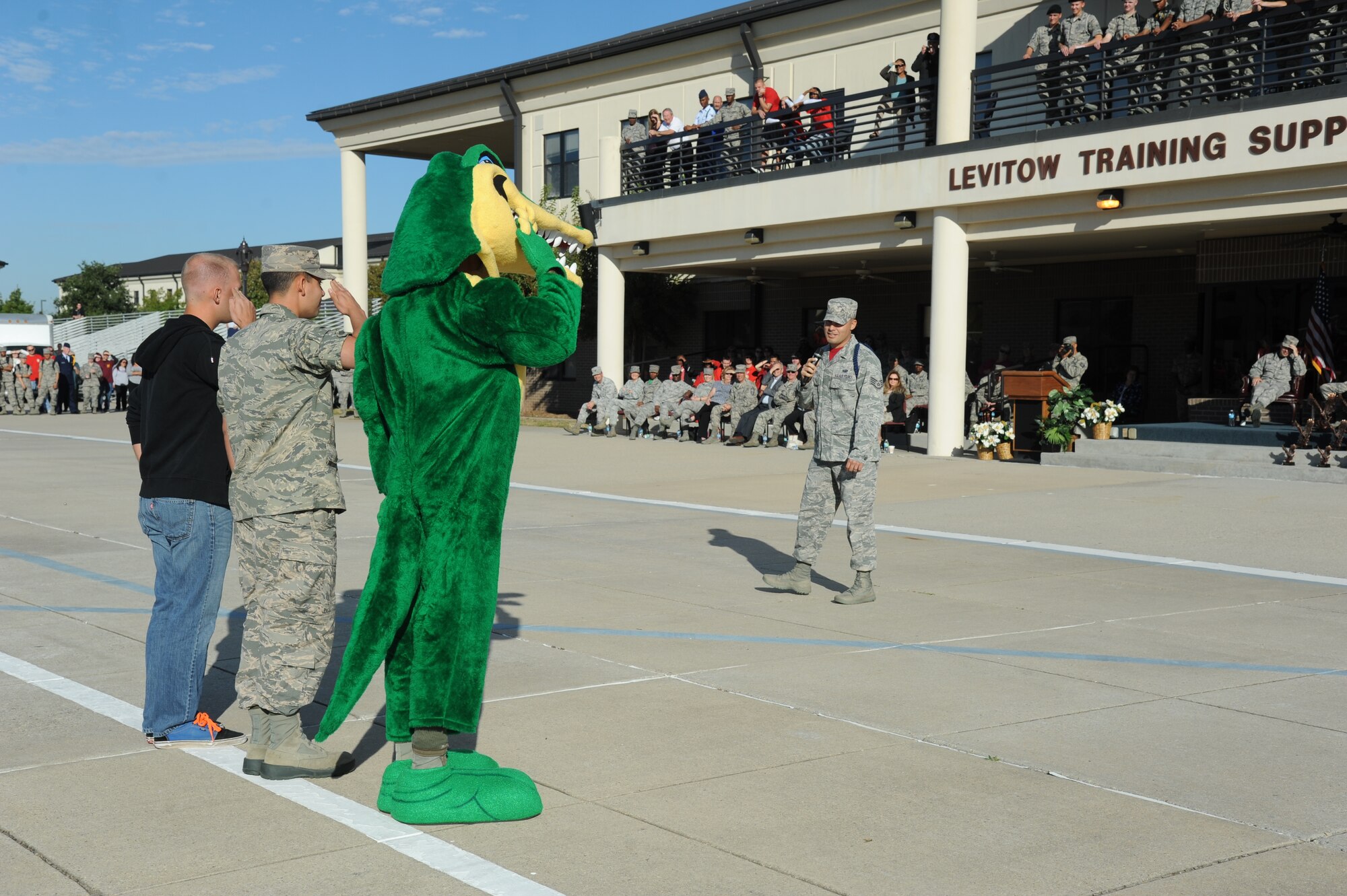 Airman 1st Class Michael Warden, 338th Training Squadron; Airman Basic Samuel Hill, 334th Training Squadron, and the 334th TRS “Gator” mascot, compete in a friendly game of Knockout Drill at the commands of Staff Sgt. Jordan Sanchez, 335th Training Squadron, during the 81st Training Group drill down Oct. 24, 2014, at the Levitow Training Support Facility Drill Pad, Keesler Air Force Base, Miss.  Hill won the competition.  (U.S. Air Force photo by Kemberly Groue)