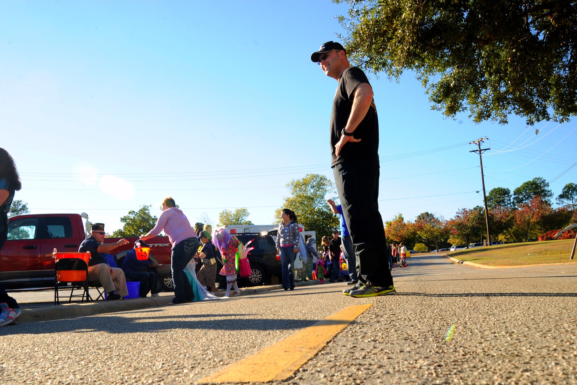 U.S. Air Force Chief Master Sgt. Charles Mills, 20th Fighter Wing command chief, observes children passing through the “Trunk-or-Treat” line at the 20th Force Support Squadron Boo Bash at Shaw Air Force Base, S.C., Oct. 25, 2014. The purpose of the event was to provide members of Team Shaw a safe trick-or-treating environment. (U.S. Air Force photo by Airman 1st Class Michael Cossaboom/Released)
