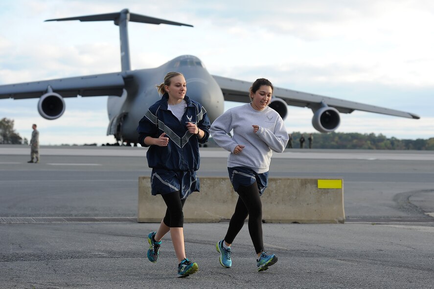 Two Airman run toward the finish-line while participating in the 2014 Wingman Day 5K Fun Run on Oct. 24, 2014, at Dover Air Force Base, Del. A C-5M Super can be seen in the background. (U.S. Air Force photo/Greg L. Davis)
