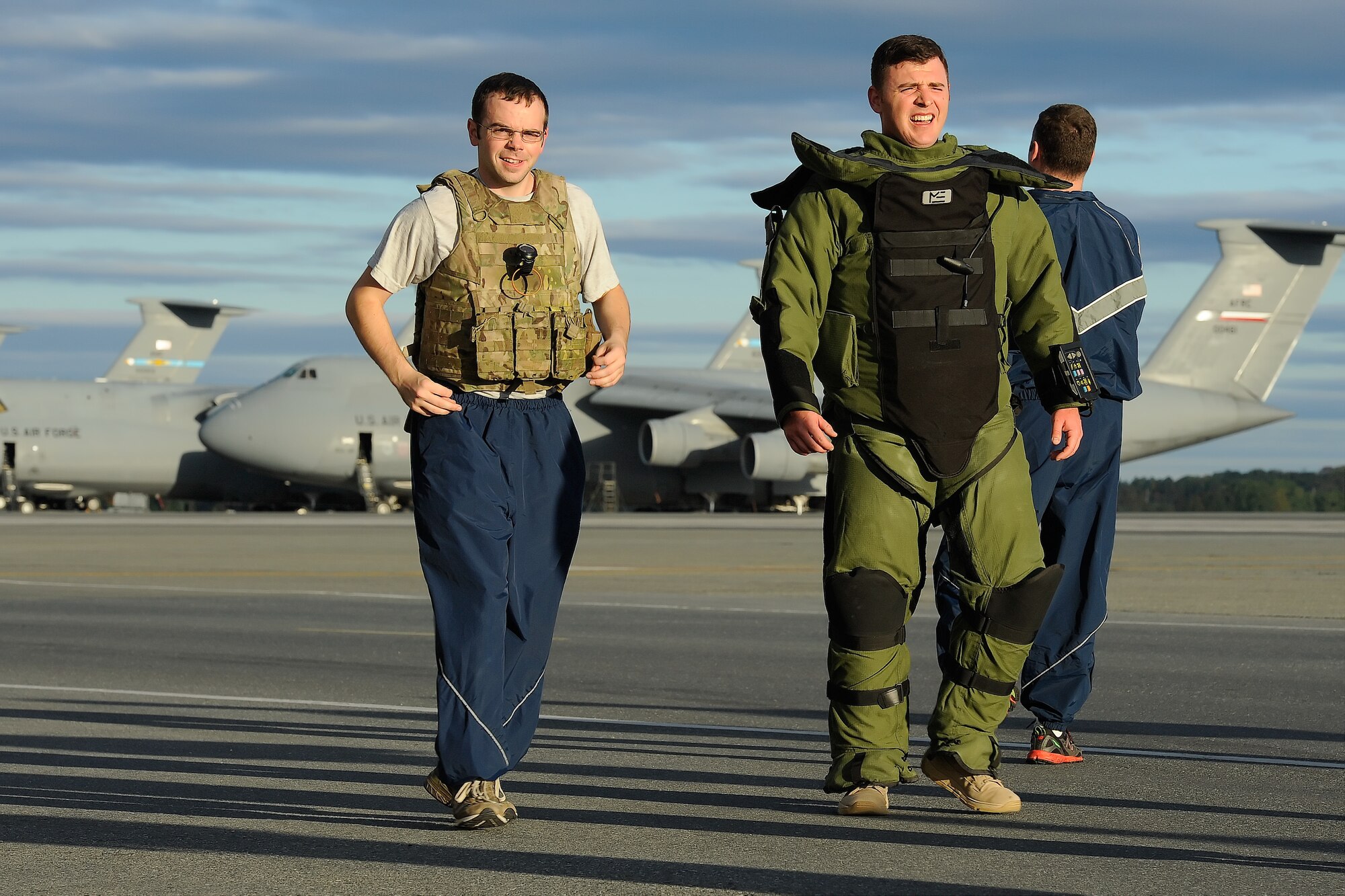 Capt. John Fuson, 436th Civil Engineer Squadron, Explosive Ordnance Disposal flight commander, breathes heavily while walking on the flight line wearing a EOD 9 bomb suit during the 2014 Wingman Day 5K Fun Run on Oct. 24, 2014, at Dover Air Force Base, Del. Fuson jogged a majority of the course and slowed down to walk and hydrate, as necessary, while taking on this personal challenge. Senior Airman Michael Poffenberger, wearing a flak-vest, acts as a safety observer and motivator for Fuson. (U.S. Air Force photo/Greg L. Davis)