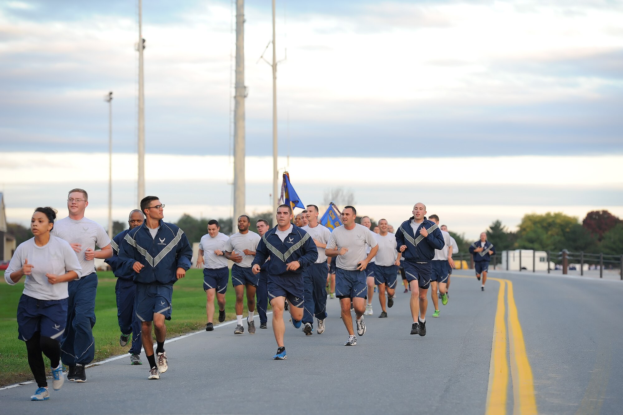 A steady stream of runners make their way towards the finish line during the 2014 Wingman Day 5K Fun Run on Oct. 24, 2014, at Dover Air Force Base, Del. Unit guidons can be seen within the crowd as they are carried to represent the unit's participation. (U.S. Air Force photo/Greg L. Davis)