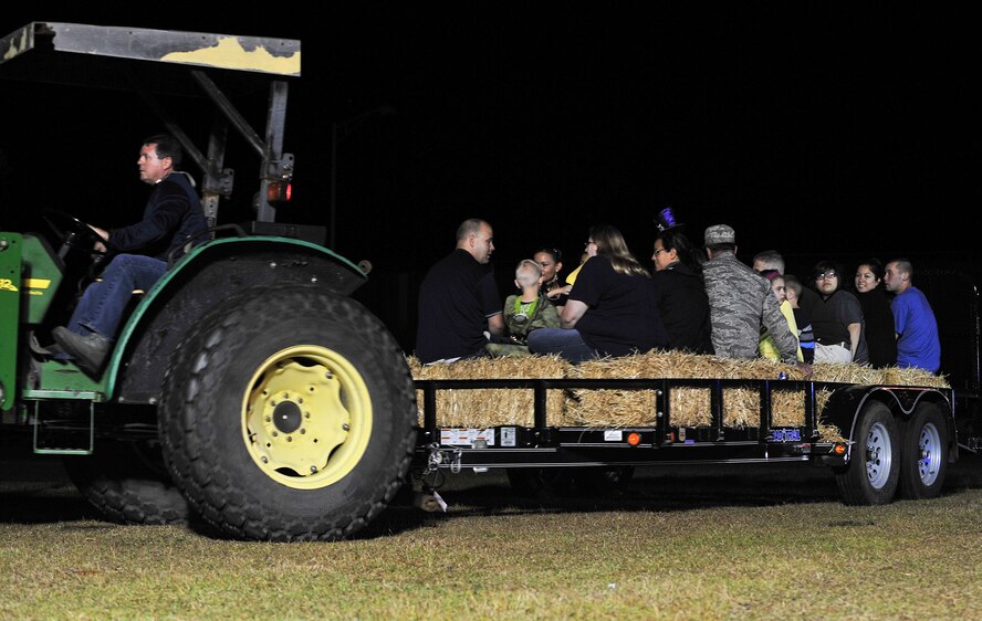Members of Team Seymour grab a seat on a hay bale for a hayride during the Halloween Block Party at Seymour Johnson Air Force Base, North Carolina, Oct. 24. (U.S. Air Force photo/Senior Airman John Nieves Camacho)