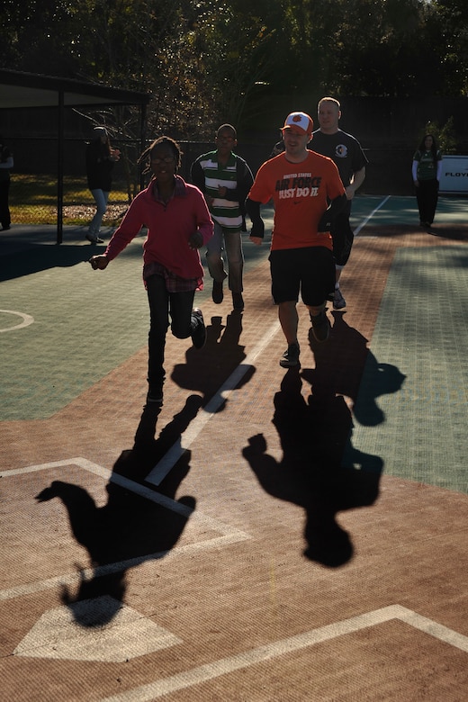 Tamara and her twin brother Tamarick, Miracle League participants, run for home plate during a baseball game with Senior Airman Michael Sulima and Staff Sgt. John Price, 437th Maintenance Squadron on Oct. 25, 2014, in Summerville, S.C. The Miracle League is a league of special needs children who play baseball with the assistance of volunteer buddies. (U.S. Air Force photo/Staff Sgt. Renae Pittman)