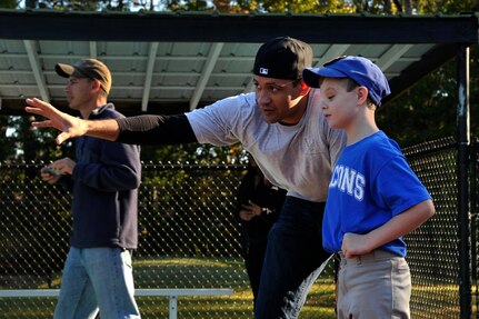 Staff Sgt. Westmoreland, 437th Maintenance Squadron, identifies different positions in the outfield to Dalton, a Falcons team member, during a Miracle League baseball game on Oct. 25, 2014, in Summerville, S.C. Westmoreland volunteered with 12 others Airmen from the 437th MSX, to assist the children with a game of baseball. The Miracle League helps special needs children who play baseball with the assistance of volunteer buddies.(U.S. Air Force photo/Staff Sgt. Renae Pittman)