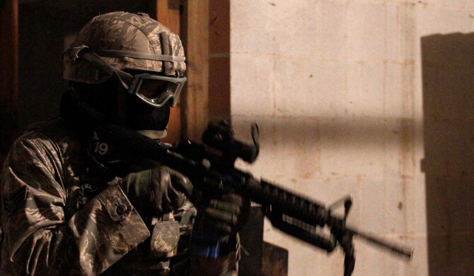 A member of the 302nd Security Forces Squadron dressed in partial battle rattle prepares to engage in a live force on force scenario Oct. 4, at Fort Carson, Colo. About 45 members of the 302nd SFS participated in live field exercises during the evening to create realistic combat situations. (U.S. Air Force photo/Staff Sgt. Nathan Federico) 

