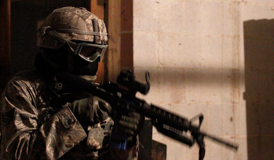 A member of the 302nd Security Forces Squadron dressed in partial battle rattle prepares to engage in a live force on force scenario Oct. 4, at Fort Carson, Colo. About 45 members of the 302nd SFS participated in live field exercises during the evening to create realistic combat situations. (U.S. Air Force photo/Staff Sgt. Nathan Federico) 

