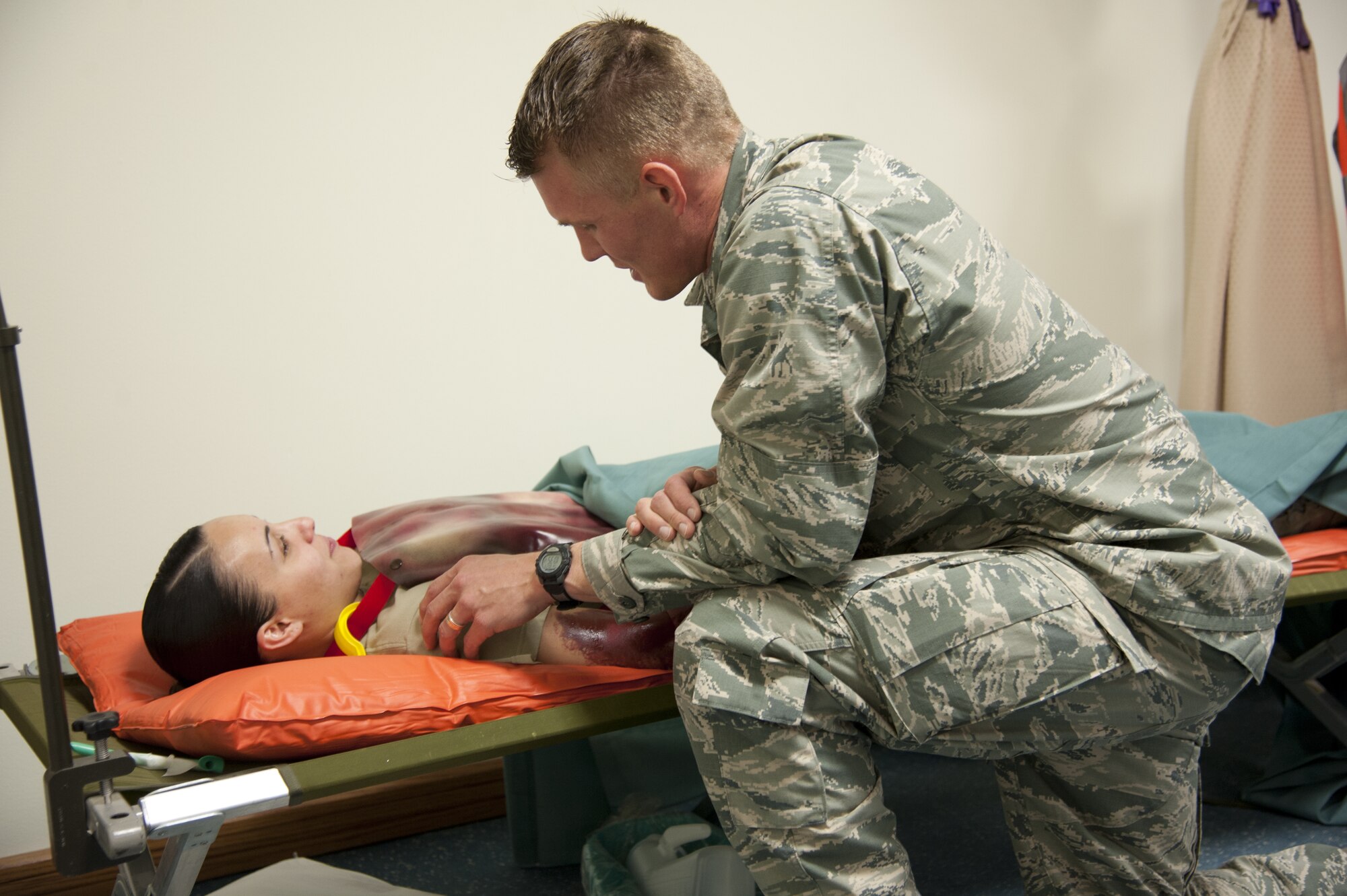 CHEYENNE MOUNTAIN AIR FORCE STATION, Colo. — Chaplain (1st Lt.) Joshua Flynn, 21st Space Wing chaplain, kneels next to a simulated wound victim that medical staff has deemed will pass away due to her injuries. During this critical moment in life, clergy personnel are responsible for providing comfort and administering Last Rites, a tradition that has carried on from the earliest days on the battlefield. This was all part of the Vigilant Shield exercise Oct. 20-26 where CMAFS team members responded to real-world scenarios that could take place within the mountain. (U.S. Air Force photo/Michael Golembesky)