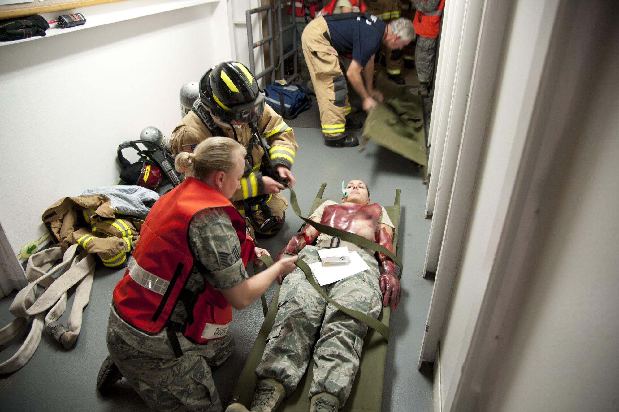 CHEYENNE MOUNTAIN AIR FORCE STATION, Colo. — A Cheyenne Mountain firefighter and medical staff personnel secure a simulated burn victim to a stretcher to transport them to the medical facility within the building complex. This was all part of the Vigilant Shield exercise Oct. 20-26 where CMAFS team members responded to real-world scenarios that could take place within the mountain. (U.S. Air Force photo/Michael Golembesky)
