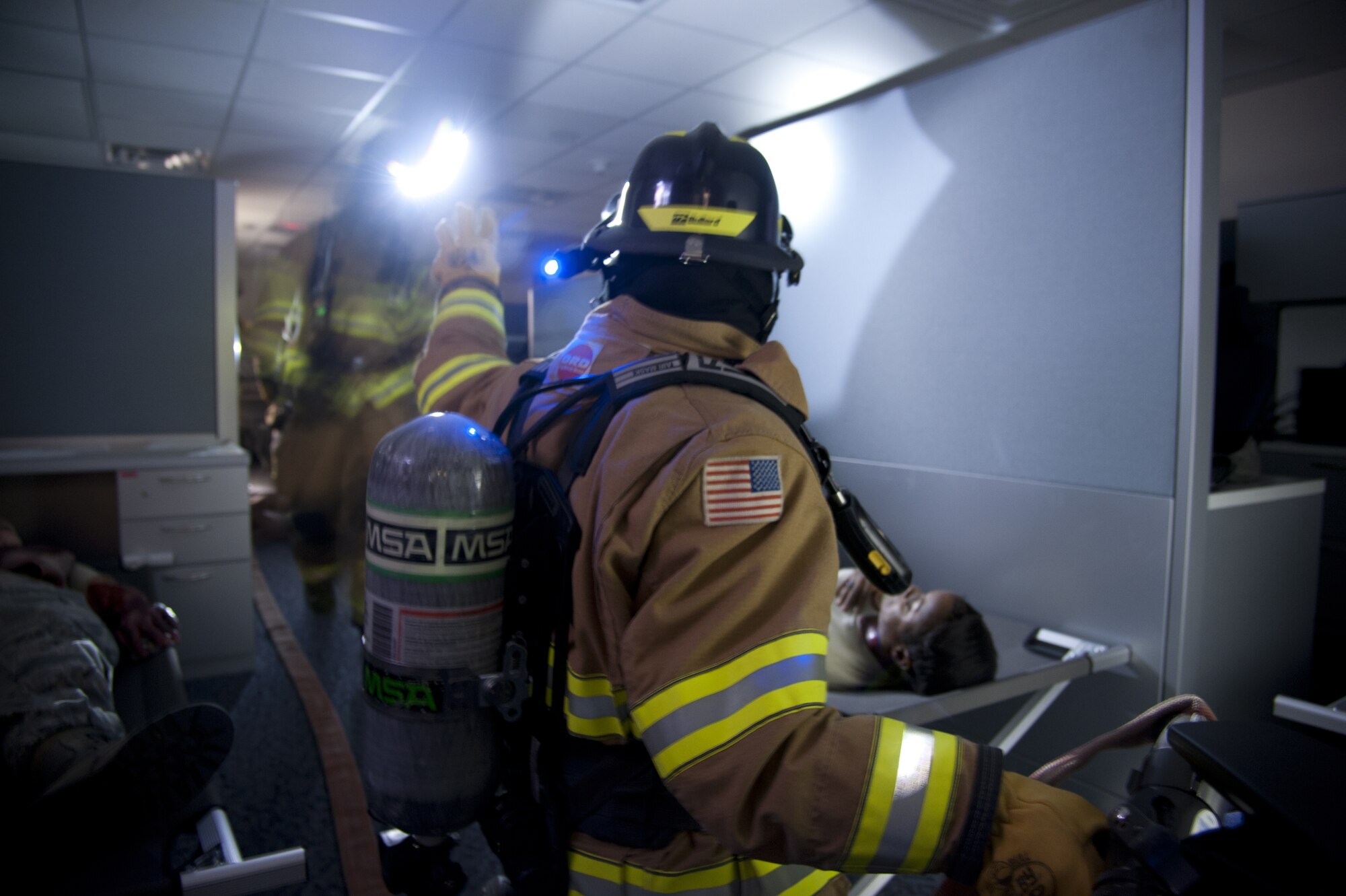 CHEYENNE MOUNTAIN AIR FORCE STATION, Colo. — A firefighter with the Cheyenne Mountain Fire Department signals to his fellow firefighter that he has three wounded personnel during a simulated fire in a berthing area within the mountain complex. The scenario was part of the Vigilant Shield exercise Oct. 20-26 where CMAFS team members responded to real-world scenarios that could take place within the mountain. (U.S. Air Force photo/Michael Golembesky)