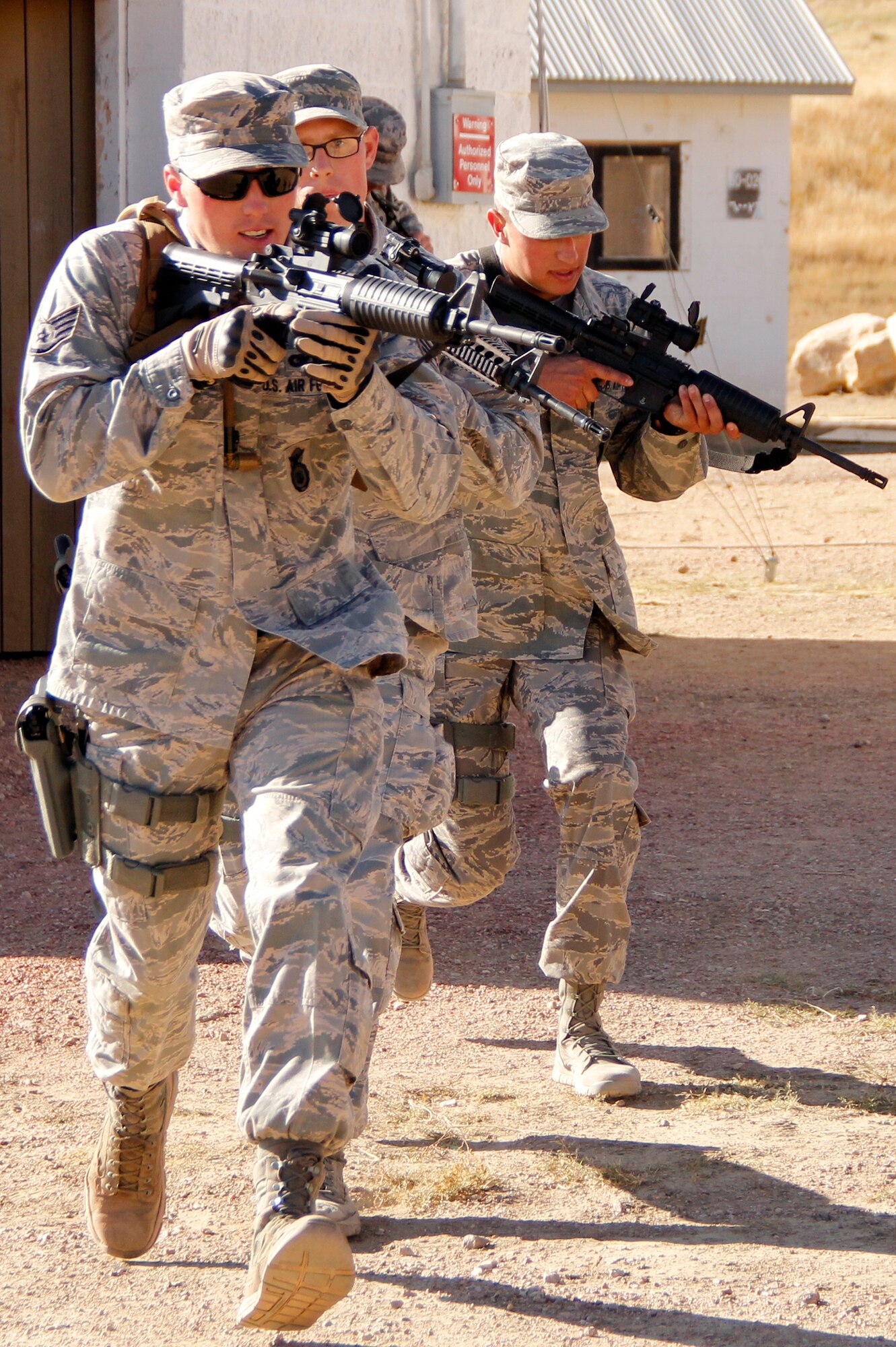 Members of the 302nd Security Forces Squadron stay alert as they quickly approach a building during field training exercises at Fort Carson, Colo. Approximately 45 members of the 302nd SFS camped out at Fort Carson to train day and night during the October Unit Training Assembly. (U.S. Air Force photo/Staff Sgt. Nathan Federico)