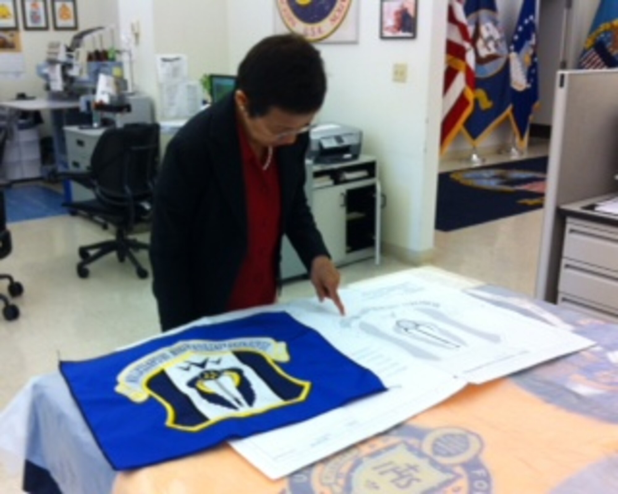 The final test sample is inspected against the blueprint for accuracy and embroidery quality. (Courtesy Photo)