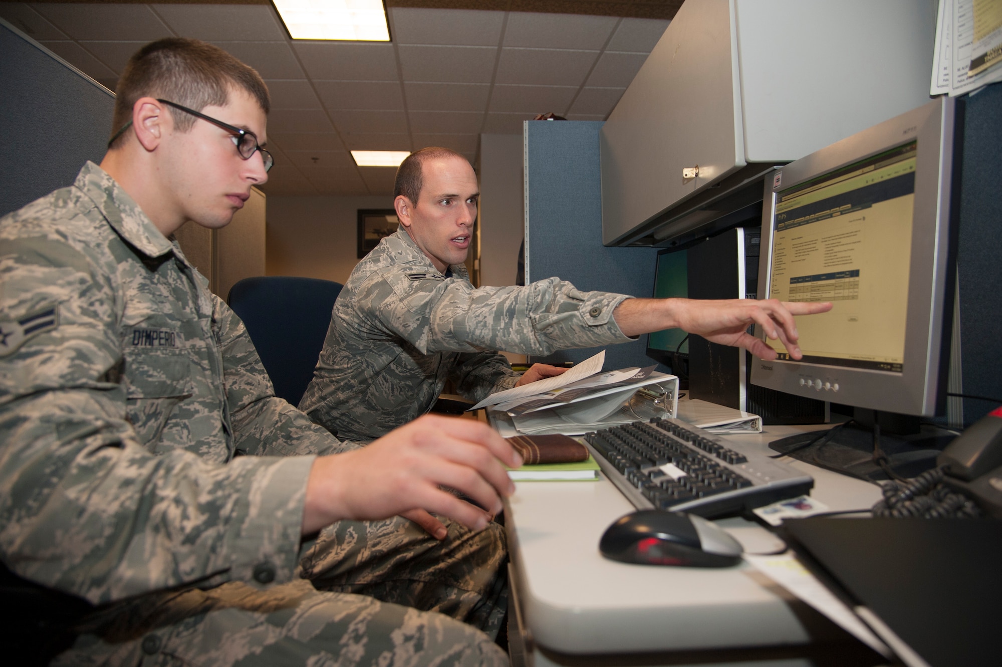 PETERSON AIR FORCE BASE, Colo. – Airman 1st Class David Farrey (right), 21st Comptroller Squadron service technician, helps Airman 1st Class Joseph Dimperio, 13th Air Support Operations Squadron tactical air control party member, in-process at the base finance office Oct. 17. The 21st CPTS assists members of Peterson AFB with any finance-related issues they may have, such as trouble filing travel vouchers or ensuring members are receiving the correct pay. (U.S. Air Force photo/Staff Sgt. J. Aaron Breeden)