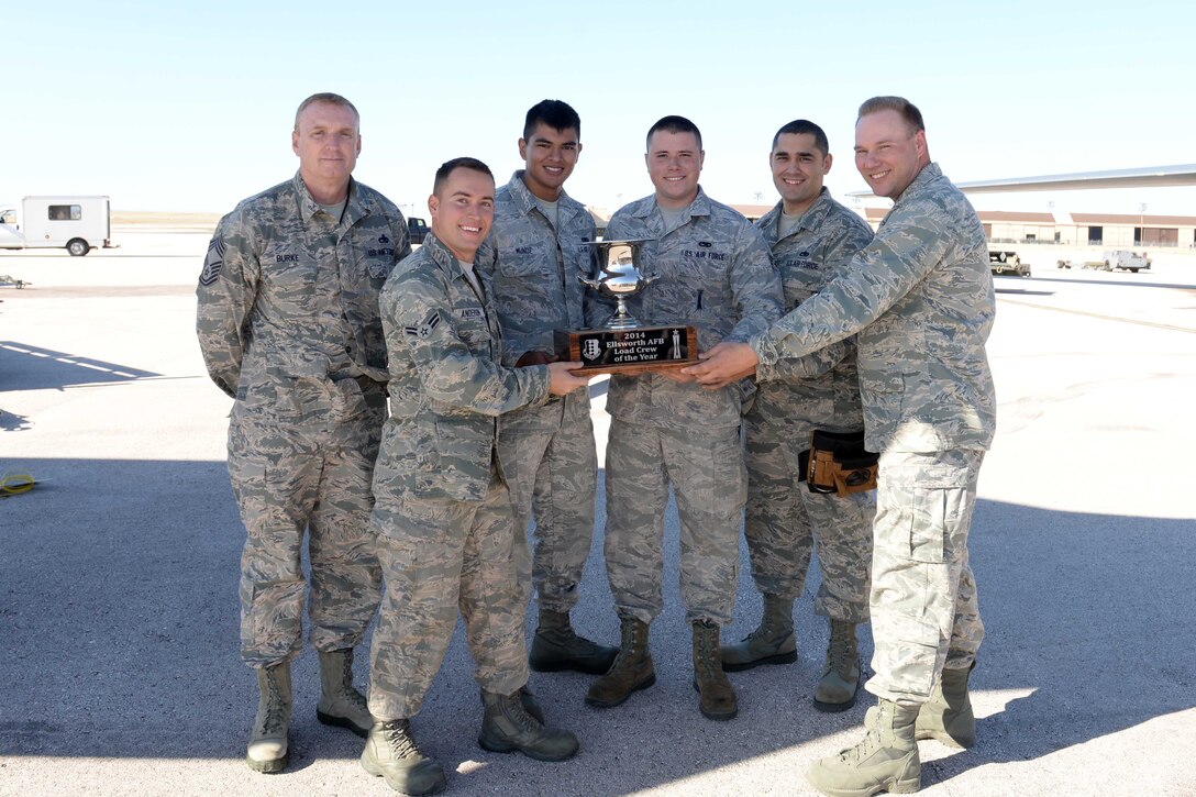 Col. Brooks McFarland, 28th Maintenance Group commander, (right) and Chief Master Sgt. Jeffrey Burke, 28th Bomb Wing weapons manager, (left) present the 34th Aircraft Maintenance Unit load crew with the trophy for the 2014 load crew of the year on the flightline at Ellsworth Air Force Base, S.D. Oct. 20, 2014. The 34th AMU load crew won the title by recording the fastest munition load times with the fewest errors. (U.S. Air Force photo by Airman 1st Class Rebecca Imwalle/Released)