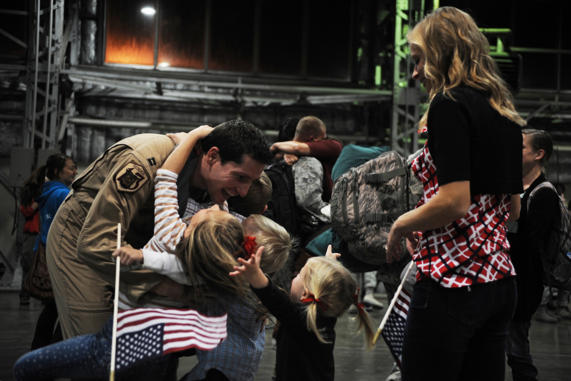 U.S. Air Force Capt. Jefferson Page, 13th Fighter Squadron F-16 Fighting Falcon pilot, hugs his children at Misawa Air Base, Japan, after returning from a six-month deployment Oct. 14, 2014. During the deployment, members of the 13 FS supported the U.S. Air Forces Central Command mission by aggressively planning, preparing and presenting executable options to the commanders while standing ready to support contingency operations. (U.S. Air Force photo by Airman Jordyn Rucker/Released)