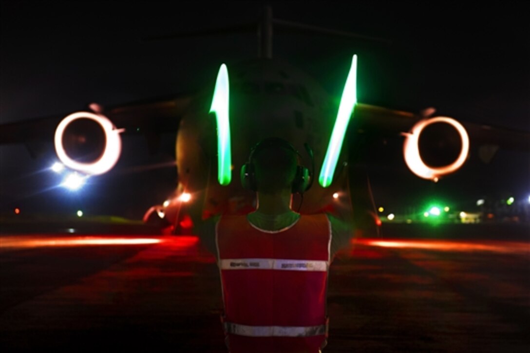 Air Force Staff Sgt. Chris Olmsted directs a C-17 Globemaster III in Monrovia, Liberia, as part of Operation United Assistance, Oct. 23, 2014. Olmsted is part of the Joint Task Force-Port Opening team assigned to the 621st Contingency Response Wing, Joint Base McGuire-Dix-Lakehurst, N.J. 