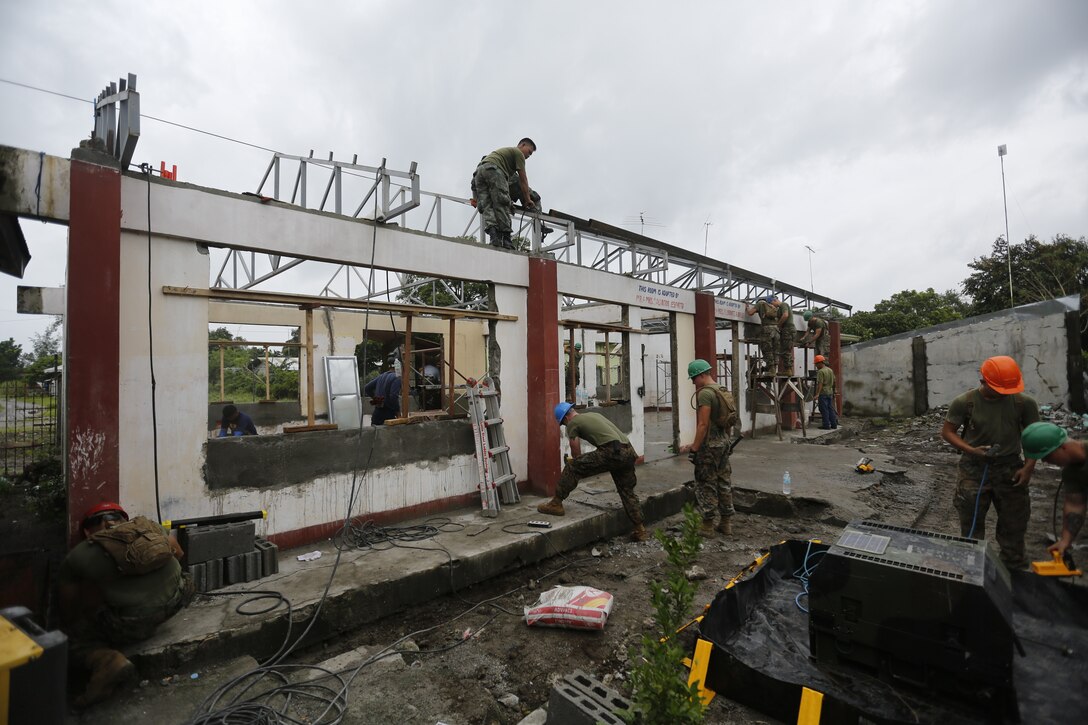 U.S. Marines with 1st Platoon, Bravo Company, 9th Engineer Support Battalion, 3d Marine Logistics Group and Philippine Navy Seabees, repair a Beddeng-Mabangcal  Elementary School classroom leading up to Amphibious Landing Exercise (PHIBLEX) 15 in Beddeng-Mabangcal, Zambales, Philippines, Sept. 20, 2014. PHIBLEX improves interoperability between the U.S. and the Philippines to increase readiness and response to natural disasters or other regional contingencies, and to enhance local infrastructure and quality of life. (U.S. Marine Corps photo by MCIPAC Lance Cpl. Colby J. Cooper/RELEASED)