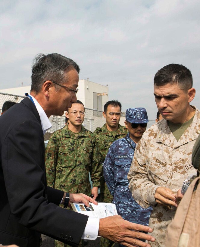Masakazu Yoshida, the Defense Councilor for Acquisition Reform, Internal Bureau, asks Maj. Giuseppe Stavale, at Fleet Activities Yokosuka, Japan. Marines with Marine Medium Tiltrotor Squadron 265 showcased the MV-22 Osprey’s capabilities, so the Japanese can continue to learn about and familiarize themselves with the Osprey. Stavale is 1st Marine Aircraft Wing’s foreign area officer. The Marines and osprey are with Marine Aircraft Group 36, 1st MAW, III Marine Expeditionary Force. 