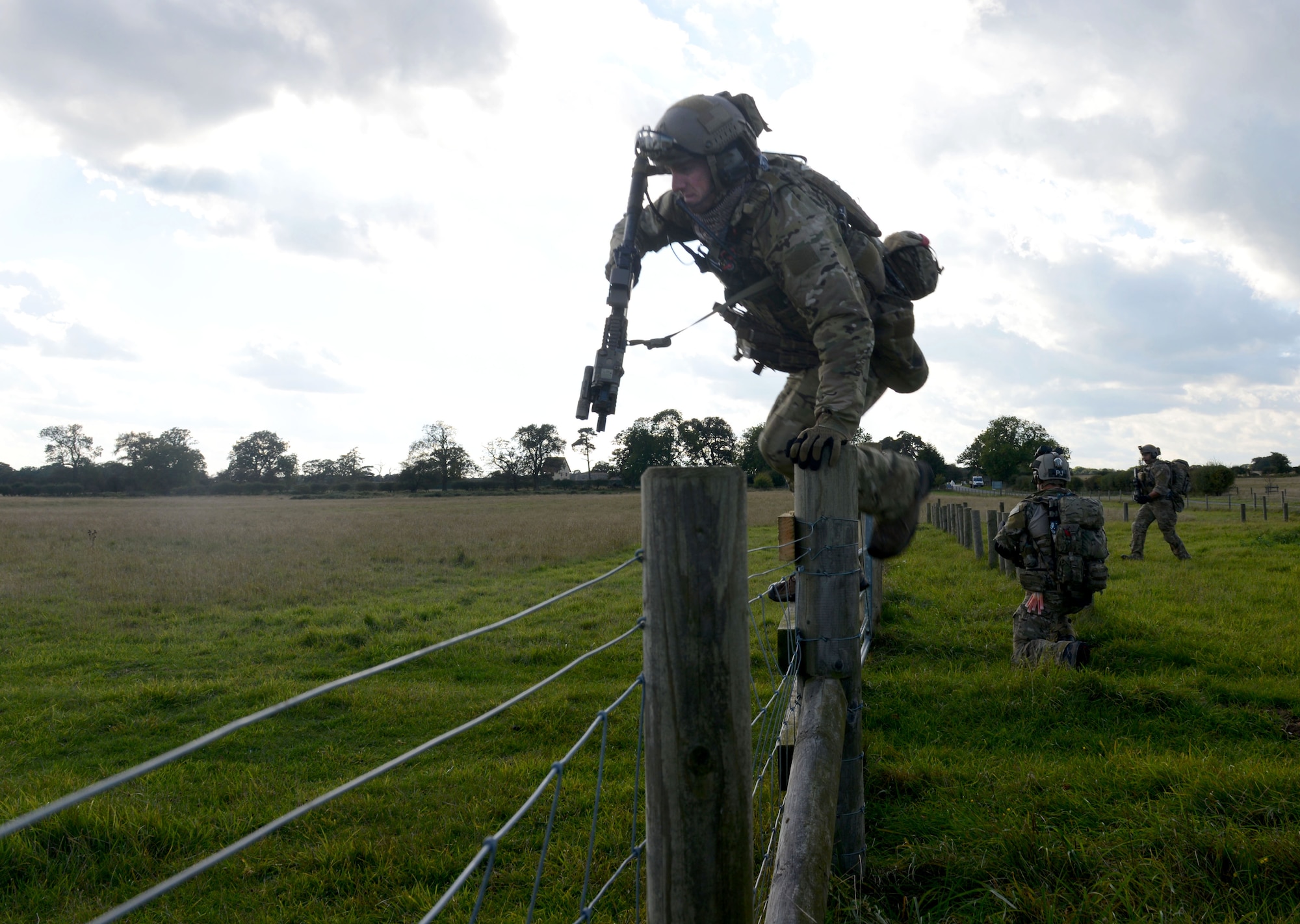 A U.S. Air Force combat controller jumps a fence while responding to a simulated village under attack during a training exercise Oct. 7, 2014, at Stanford Training Area near Thetford, England. The exercise was designed to familiarize special tactics Airmen with combat scenarios to prepare them for  real-world incidents. (U.S. Air Force photo/Senior Airman Kate Maurer/Released)