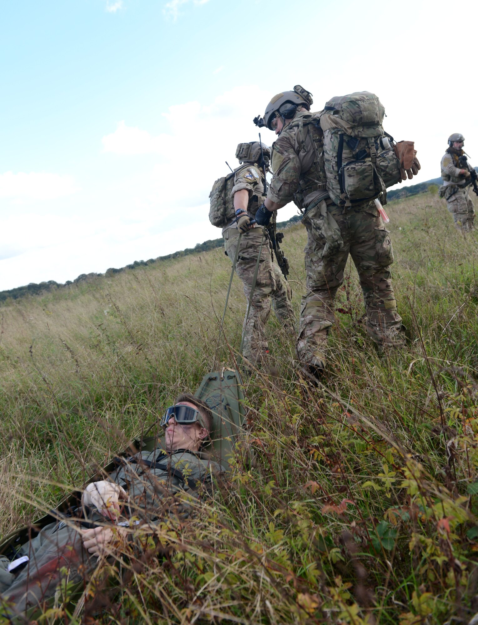 A U.S. Air Force combat controller, center, and a U.S. Air Force pararecueman, right, pull a fake victim from a simulated village under attack during a training exercise Oct. 7, 2014, at Stanford Training Area near Thetford, England. The exercise was designed to familiarize special tactics Airmen with combat scenarios preparing them for the possibilities of real-world incidents. (U.S. Air Force photo/Senior Airman Kate Maurer/Released)