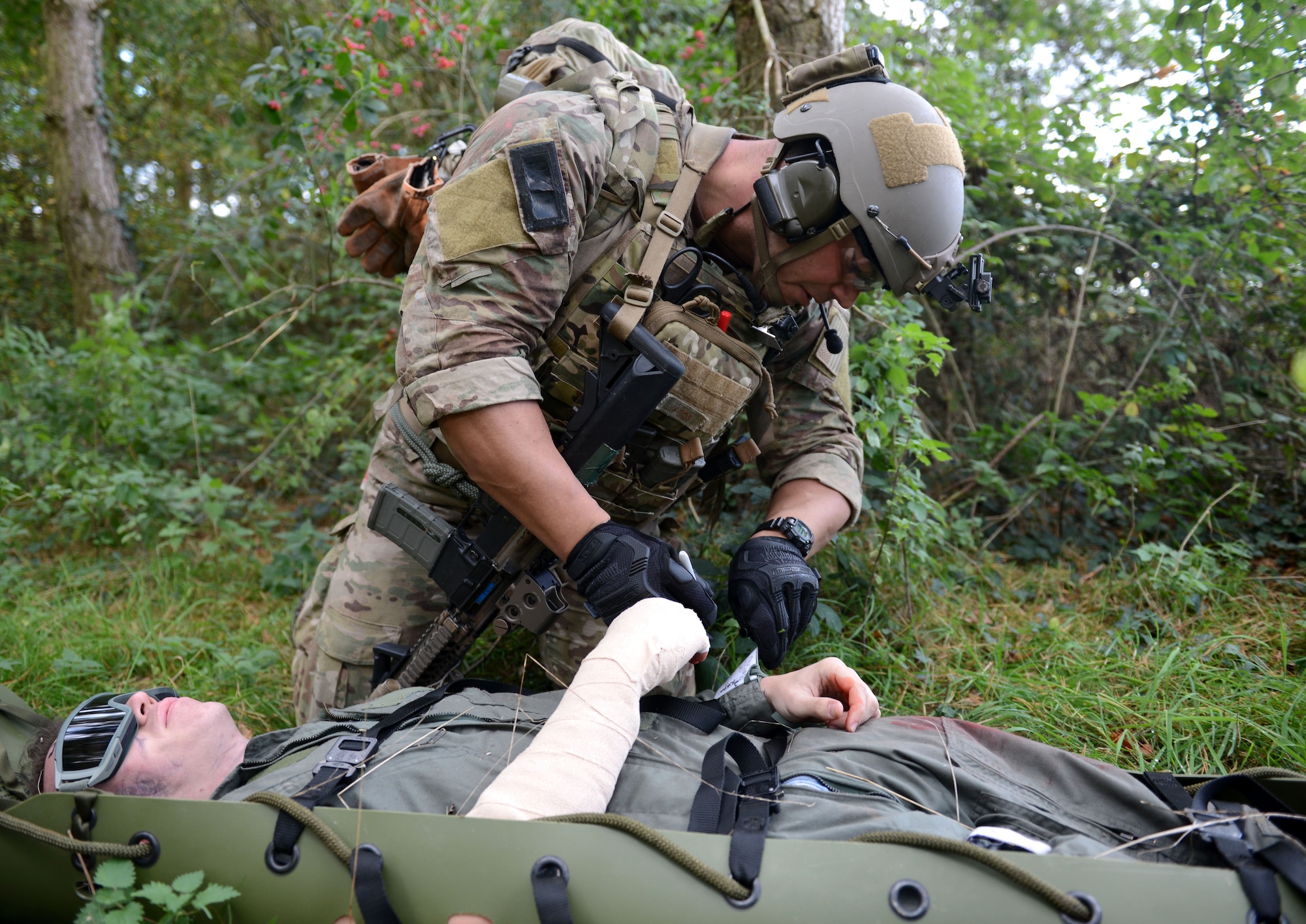 A U.S. Air Force pararecueman helps a simulated victim during a training exercise Oct. 7, 2014, at Stanford Training Area near Thetford, England. Pararescuemen are paramedics who often embed with special operations forces and rescue and recover personnel in hostile environments. The exercise was designed to familiarize special tactics Airmen with combat scenarios preparing them for  real-world incidents. (U.S. Air Force photo/Senior Airman Kate Maurer/Released)