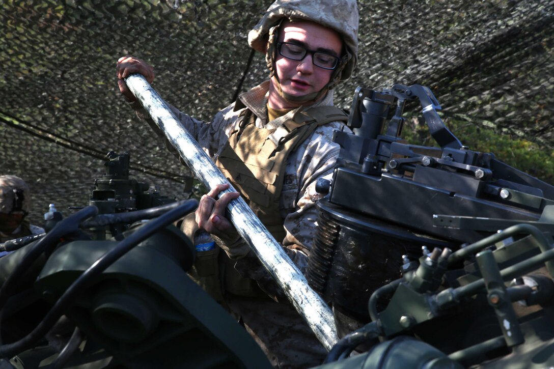 Lance Cpl. James Conley, a field artilleryman with 3rd Battalion, 14th Marine Regiment, 4th Marine Division, cleans the barrel of the M777A2 Lightweight Howitzer after firing rounds at Fort Indiantown Gap, Pa., during exercise Twisted Sister,  a battalion fire exercise, Oct. 25, 2014. The purpose of swabbing the barrel after each firing is to ensure that the gun is sufficiently cooled so as not to prematurely ignite the next group of powder placed into the gun. (Marine Corps Photo by Cpl. J. Gage Karwick/Released)