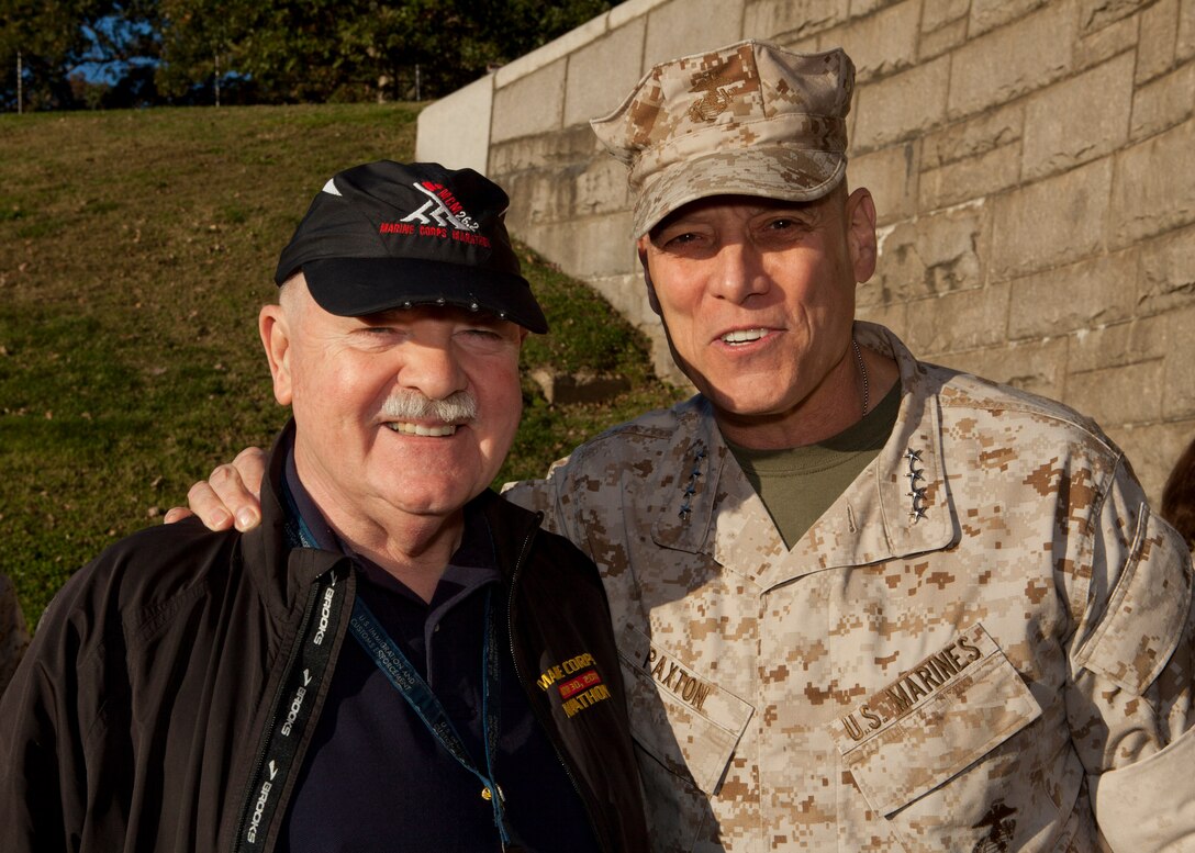 The Assistant Commandant of the Marine Corps, Gen. John M. Paxton, Jr., right, poses for a photo during the 39th Marine Corps Marathon, at the Marine Corps War Memorial, Arlington, Va., Oct. 26, 2014. The Marathon consisted of approximently 30,000 participants routing their way through Arlington, up Rock Creek Parkway, along the monuments and past the Pentagon, finishing at the Marine Corps War Memorial.  (U.S. Marine Corps photo by Cpl. Tia Dufour/Released)