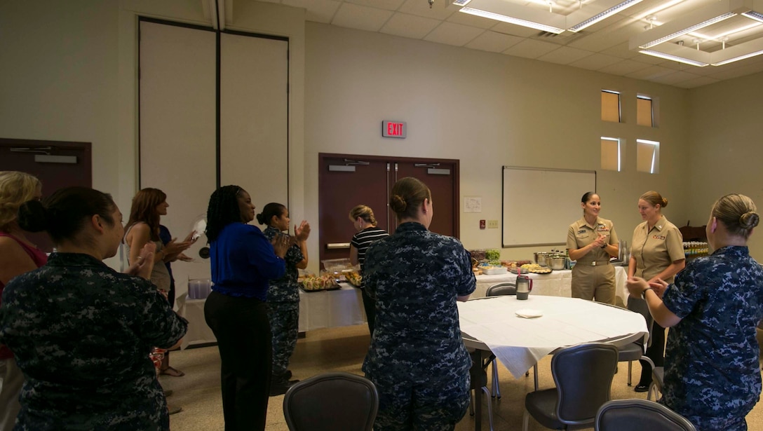 Attendees of a Women’s Symposium applaud Hospital Corpsman Second Class Michelle Asbjornsen during the event, which was hosted and sponsored by the Naval Branch Health Clinic at Marine Corps Air Station Yuma, Ariz., Thursday, Aug. 28, 2014. The symposium focused on networking and encouragement in observance of the Defense Equal Opportunity Management Institute’s August topic of Women’s Equality.