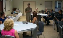 Chief Hospital Corpsman Jean Molina, standing, the senior enlisted leader at the Naval Branch Health Clinic on Marine Corps Air Station Yuma, Ariz., addresses attendees of a Women’s Symposium hosted and sponsored by the NBHC, Thursday, Aug. 28, 2014. The symposium focused on networking and encouragement within MCAS Yuma in observance of the Defense Equal Opportunity Management Institute’s August topic of Women’s Equality.