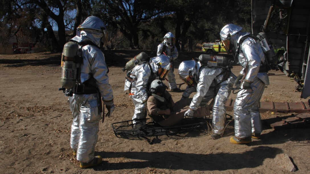 Marines with Aircraft Rescue and Firefighting, Headquarters and Headquarters Squadron, 3rd Marine Air Wing, I Marine Expeditionary Force, evacuate a simulated casualty during a mishap drill at Marine Corps Base Camp Pendleton, Calif., Oct. 27, 2014. The drill provided first responders the opportunity to practice every step of responding to a disabled aircraft including coordinating military and civilian agencies and rescuing the crew of the aircraft.