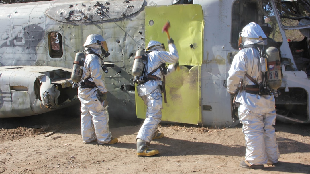 Marines with Aircraft Rescue and Firefighting, Headquarters and Headquarters Squadron, 3rd Marine Air Wing, I Marine Expeditionary Force, create an opening to evacuate simulated casualties during a mishap drill at Marine Corps Base Camp Pendleton, Calif., Oct. 27, 2014. The drill provided first responders the opportunity to practice every step of responding to a disabled aircraft including coordinating military and civilian agencies and rescuing the crew of the aircraft. 