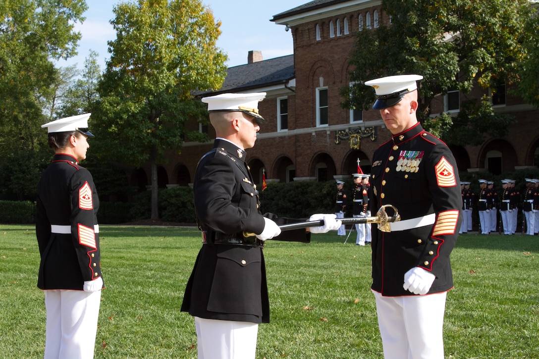 Col. Benjamin T. Watson, commanding officer of Marine Barracks Washington, D.C., passes a non-commissioned officer’s sword to the Barracks’ incoming sergeant major, Sgt. Maj. Joseph C. Gray during a relief and appointment ceremony at the Barracks Oct. 29, 2014. Gray replaces Sgt. Maj. Angela M. Maness who is assuming duties as the sergeant major for Marine Corps Recruit Depot Parris Island, S.C., and Eastern Recruiting Region.