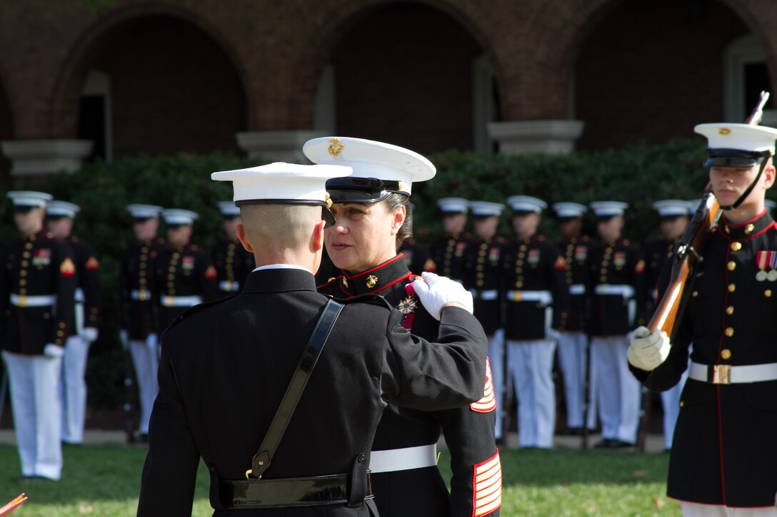 Col. Benjamin T. Watson, commanding officer of Marine Barracks Washington, D.C., presents the Legion of Merit to outgoing Barracks sergeant major, Sgt. Maj. Angela M. Maness during a relief and appointment ceremony Oct. 29, 2014. During the ceremony, Sgt. Maj. Joseph C. Gray replaced Maness who is assuming duties as the sergeant major for Marine Corps Recruit Depot Parris Island, S.C., and Eastern Recruiting Region.
