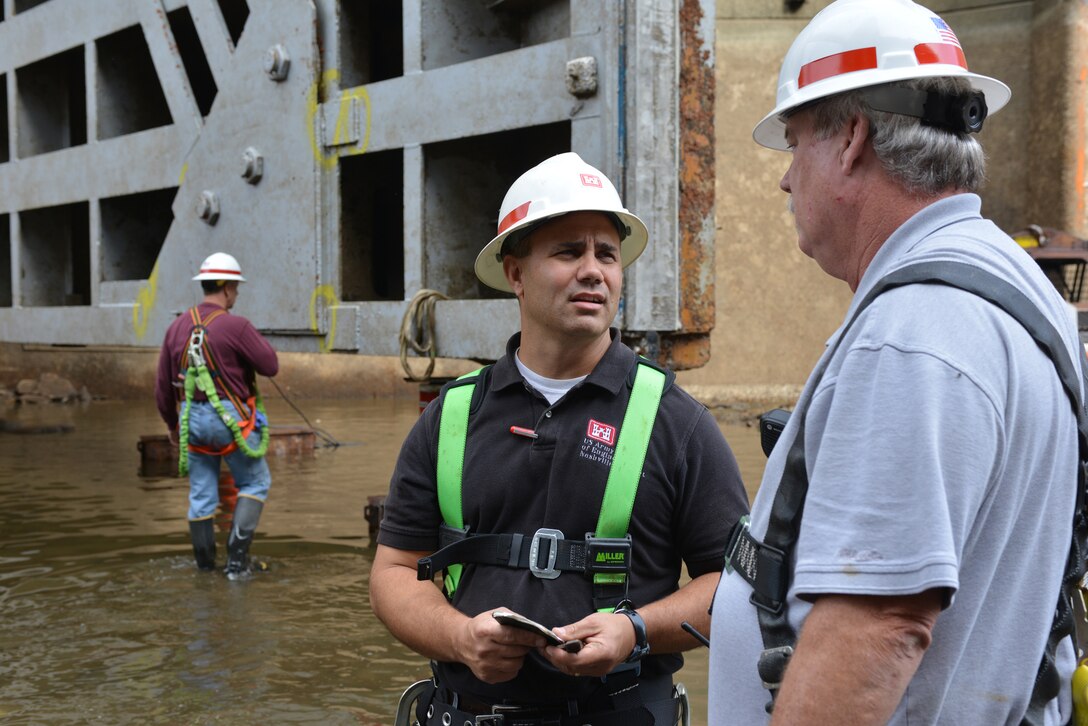 U.S. Army Corps of Engineers structural engineer, Cory Morgan, from the Nashville District Civil Design Branch’s Civil Structure Section talks with Donald Dean, assistant operations manager of the middle Tennessee River and Lockmaster at Wheeler Lock about the 67-foot miter gate as Barney Schulte,  (left) also structural engineer inspects the gate.   The Wheeler Navigational Lock is dry this week as work crews begin to inspect and repair underwater components Oct. 28, 2014.  U.S. Army Corps of Engineers Nashville District employees dewatered the 51-year-old, 110-by-600-foot lock and closely inspected the 67-foot miter gates, culvert valves and all other areas of the lower lock chamber that are normally underwater.
