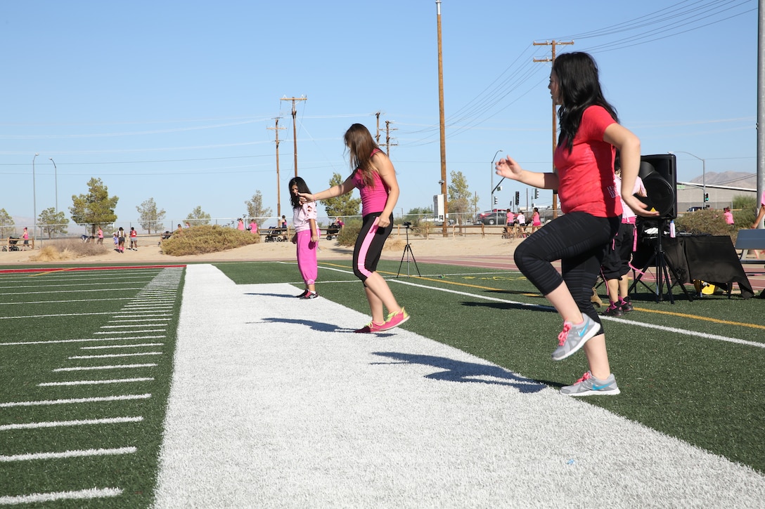 Zumba instructors begin their exercise routine during the Pink Walk to raise breast cancer awareness at Felix Field, Oct. 24, 2014. The Officers’ Spouses Club hosted the Pink Walk to raise awareness for breast cancer and give information to the community.