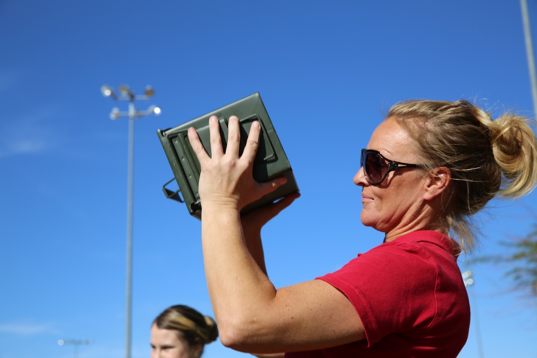 A spouse conducts the ammo can portion of the modified Combat Fitness Test during the Combined Arms Exercise for Spouses at Felix Field, Oct. 23, 2014. CAX  for Spouses is held annually and was started in 2004.