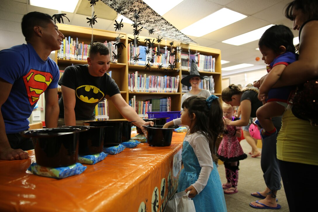 Children feel the assorted ‘human’ parts in a bowl while Marine Corps Communication-Electronics School students volunteer during the Not So Spooky Spooktacular at the Combat Center Library, Oct. 23, 2014.