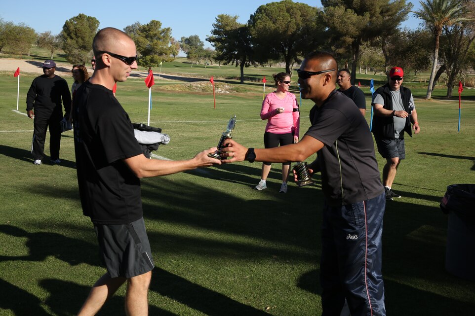 Staff Sgt. Shane Makary, ordinance maintenance platoon sergeant, Combat Logistics Batalion 13, receives a trophy for coming in second place during the Red Ribbon Week 5K race at Desert Winds Golf Course, Oct. 23, 2014.