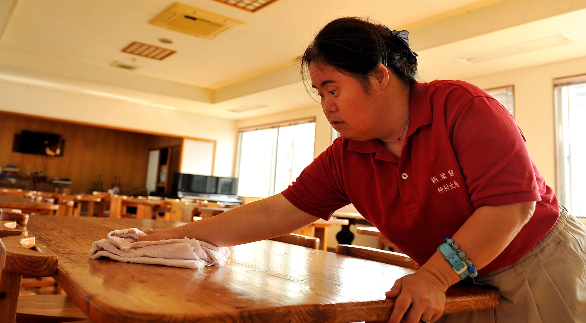 Yoshie Nakamura, welfare employment center employee, wipes a table at the Fuyo-Kan, welfare employment center, Oct. 28, 2014. Nakamura became a facility user of Fuyo-Kan, welfare employment center 24 years ago and works building maintenance at the Peare, Okinawa culture health center. (U.S. Air Force photo by Naoto Anazawa/Released)