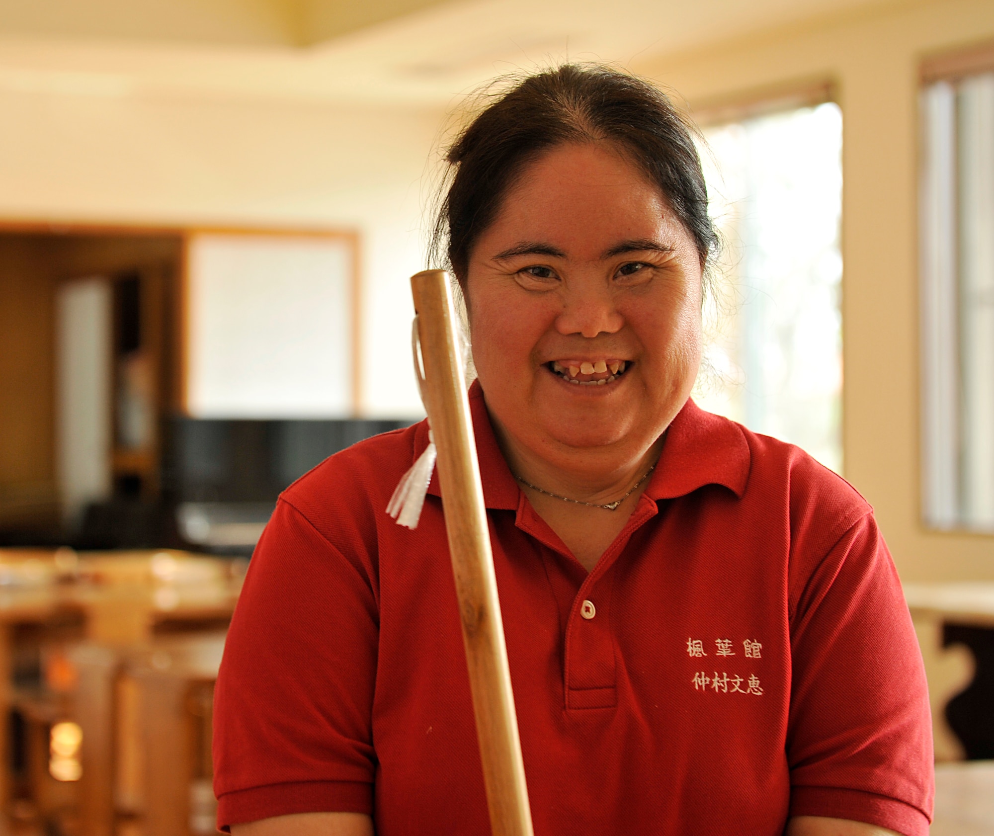 Yoshie Nakamura, welfare employment center employee, poses for a picture while sweeping at the Fuyo-Kan, welfare employment center, Oct. 28, 2014. Nakamura will be participating in her fourth Kadena Special Olympics for 50 meter and ground golf. Nakamura is looking forward to aim higher performance at this KSO. (U.S. Air Force photo by Naoto Anazawa/Released)