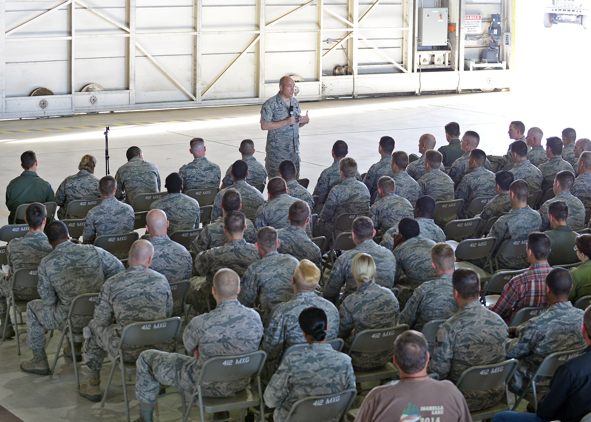 Brig. Gen. Michael Brewer, 412th Test Wing commander, addresses personnel from the 416th Flight Test Squadron and the 445th FLTS during a commander’s call held Oct. 23 in Hangar 1210 to initially discuss what will be the consolidation of the two historic squadrons into one. (U.S. Air Force photo by Jet Fabara)