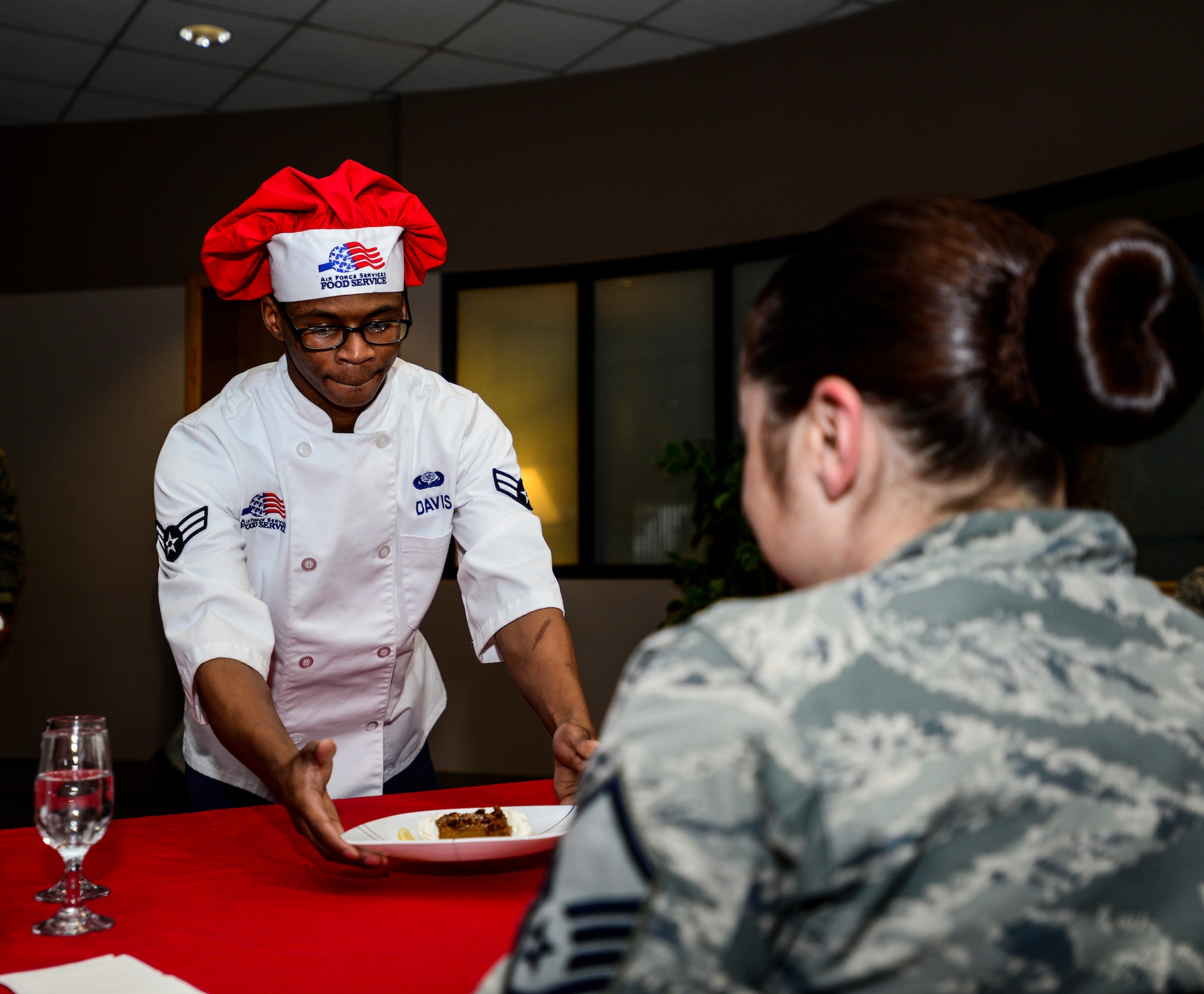 U.S. Air Force Airman 1st Class Denzel Davis, a 354th Force Support Squadron Team Davis chef, presents Master Sgt. Holly Roschel, a cooking competition judge, his team’s dessert at the Two Seasons Dining Facility, Eielson Air Force Base, Alaska, Oct. 24, 2014, during the Eielson Iron Chef of the Quarter cooking competition. The dishes had to be served to the judges at a temperature appropriate for eating. (U.S. Air Force photo by Senior Airman Racheal E. Watson/Released)