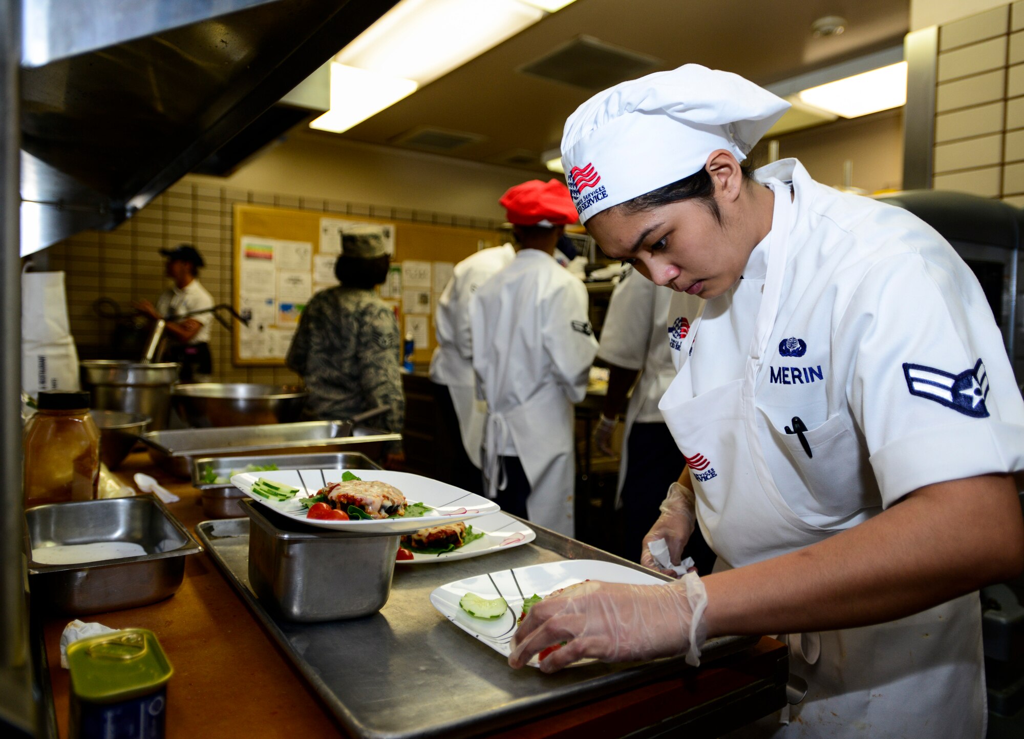 U.S. Air Force Airman 1st Class Alexis Merin, a 354th Force Support Squadron Team Davis chef, garnishes a plate at the Two Seasons Dining Facility, Eielson Air Force Base, Alaska, Oct. 24, 2014, during the Eielson Iron Chef of the Quarter cooking competition. Any dish not ready on time had the possibility of being disqualified from the competition. (U.S. Air Force photo by Senior Airman Racheal E. Watson/Released)