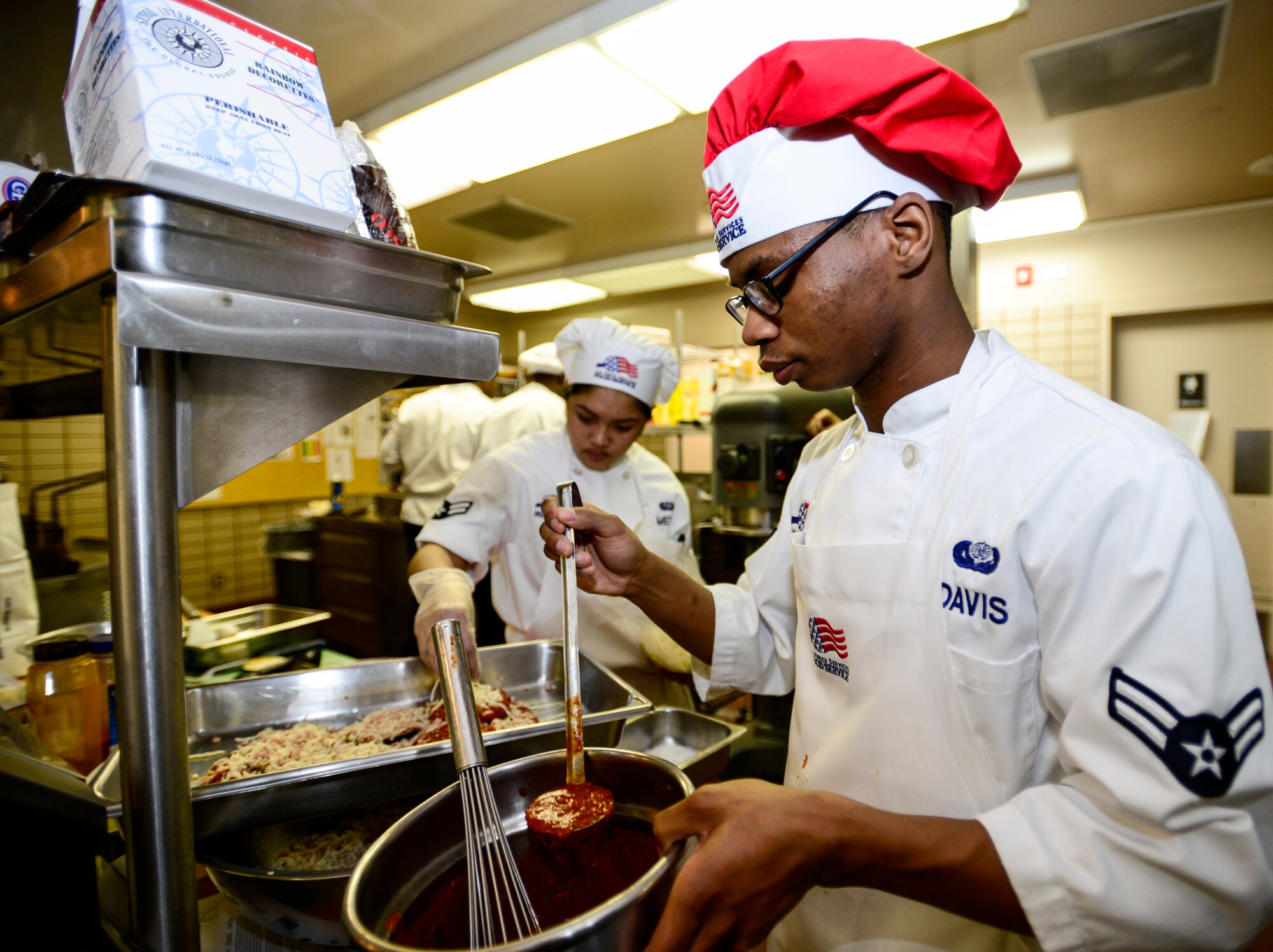U.S. Air Force Airman 1st Class Denzel Davis, a 354th Force Support Squadron Team Davis chef, ladles sauce onto his entrée at the Two Seasons Dining Facility, Eielson Air Force Base, Alaska, Oct. 24, 2014, during the Eielson Iron Chef of the Quarter cooking competition. Each team was judged on the presentation, aroma, texture, effort and degree of difficulty. (U.S. Air Force photo by Senior Airman Racheal E. Watson/Released)
