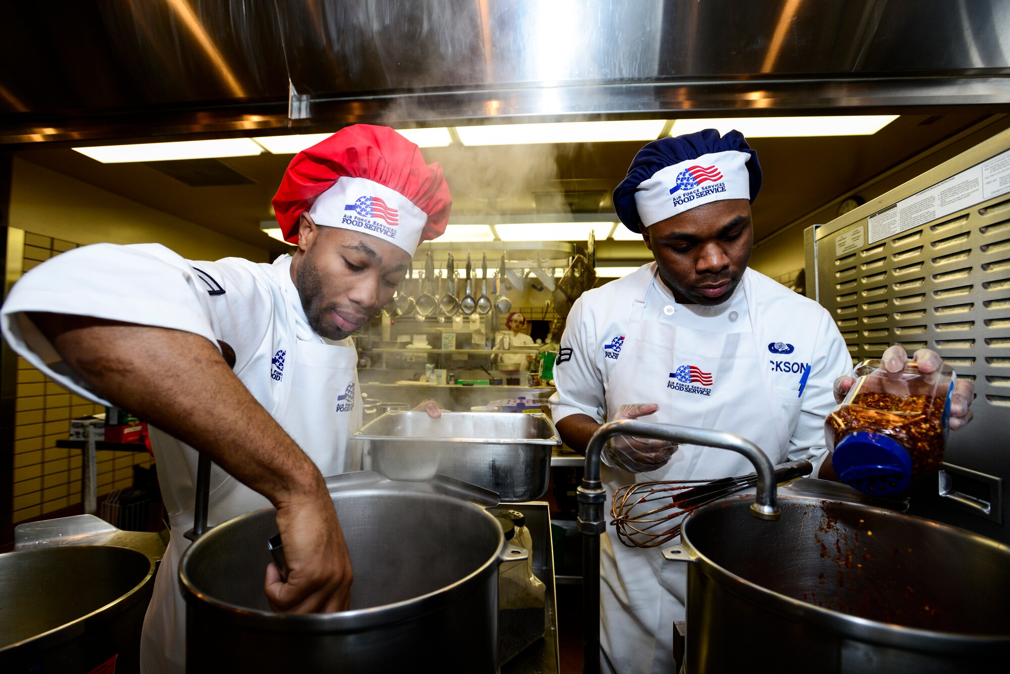 U.S. Air Force Airmen 1st Class Lazrus Lee and Elijah Jackson, 354th Force Support Squadron Team Lee chefs, stir and add ingredients to their dishes at the Two Seasons Dining Facility, Eielson Air Force Base, Alaska, Oct. 24, 2014, during a cooking competition. As part of the competition rules, all four ingredients had to be used in the appetizer, entrée or dessert. (U.S. Air Force photo by Senior Airman Racheal E. Watson/Released)