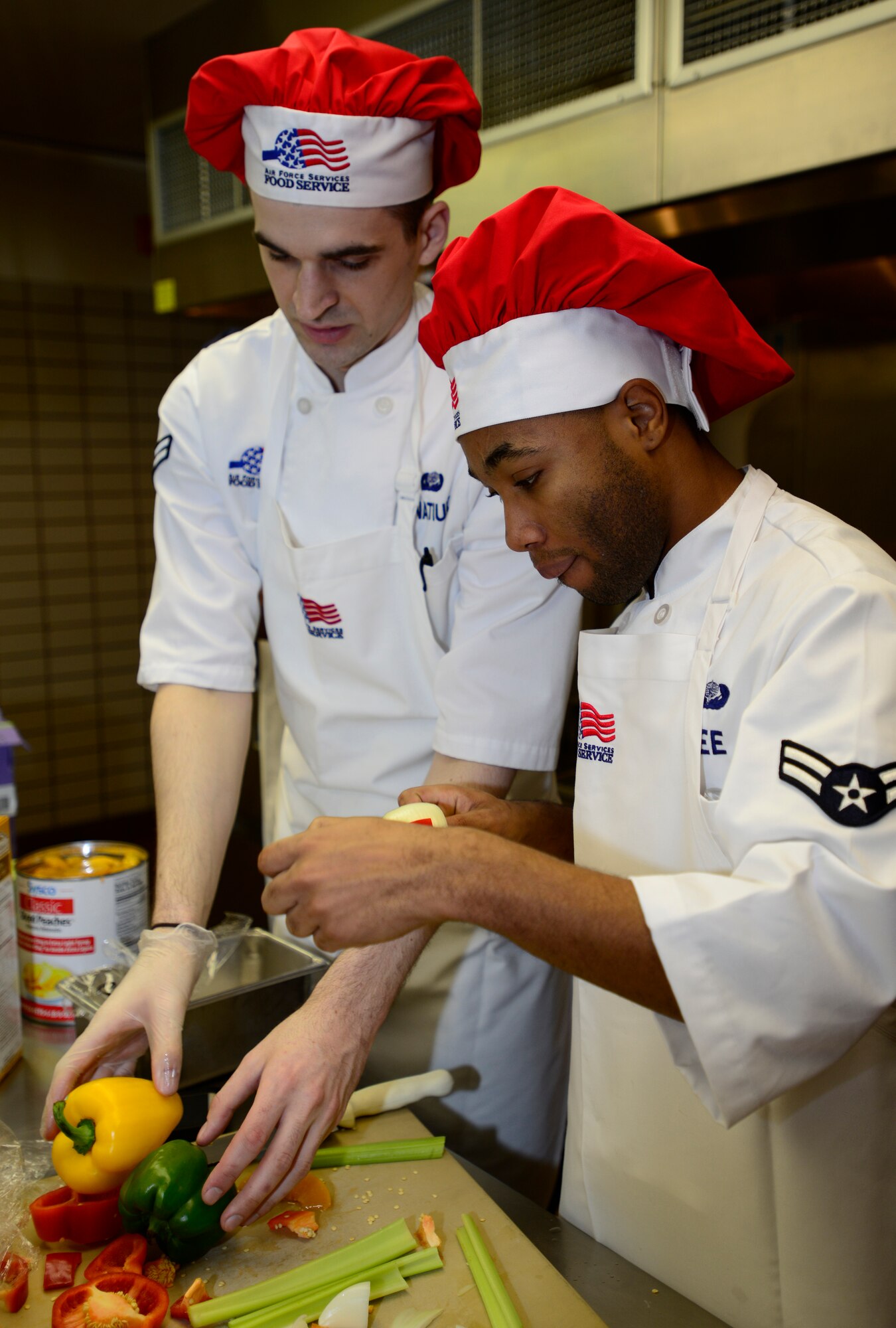 U.S. Air Force Airmen 1st Class Jeremy Hnatiuk and Lazrus Lee, 354th Force Support Squadron Team Lee chefs, discuss presentation techniques for the shish kabobs at the Two Seasons Dining Facility, Eielson Air Force Base, Alaska, Oct. 24, 2014, during the Eielson Iron Chef of the Quarter cooking competition. Each team had two and a half hours to complete three dishes; an appetizer, an entrée and a dessert. (U.S. Air Force photo by Senior Airman Racheal E. Watson/Released)