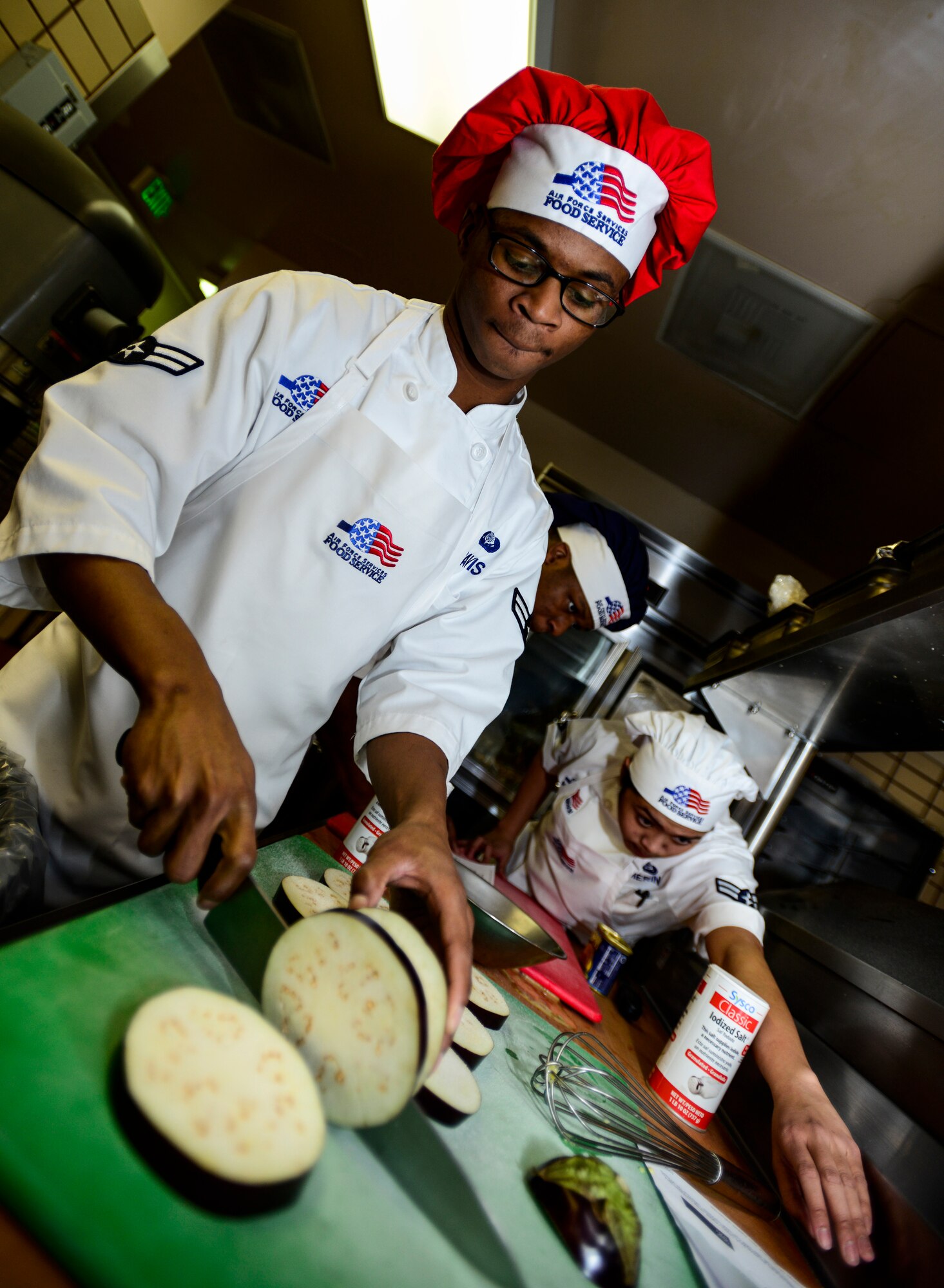 U.S. Air Force Airman 1st Class Denzel Davis, a 354th Force Support Squadron Team Davis chef, slices an eggplant at the Two Seasons Dining Facility, Eielson Air Force Base, Alaska, Oct. 24, 2014, during a cooking competition.  Two chefs and their teams battled for recognition as Eielson’s Iron Chef of the Quarter. (U.S. Air Force photo by Senior Airman Racheal E. Watson/Released)