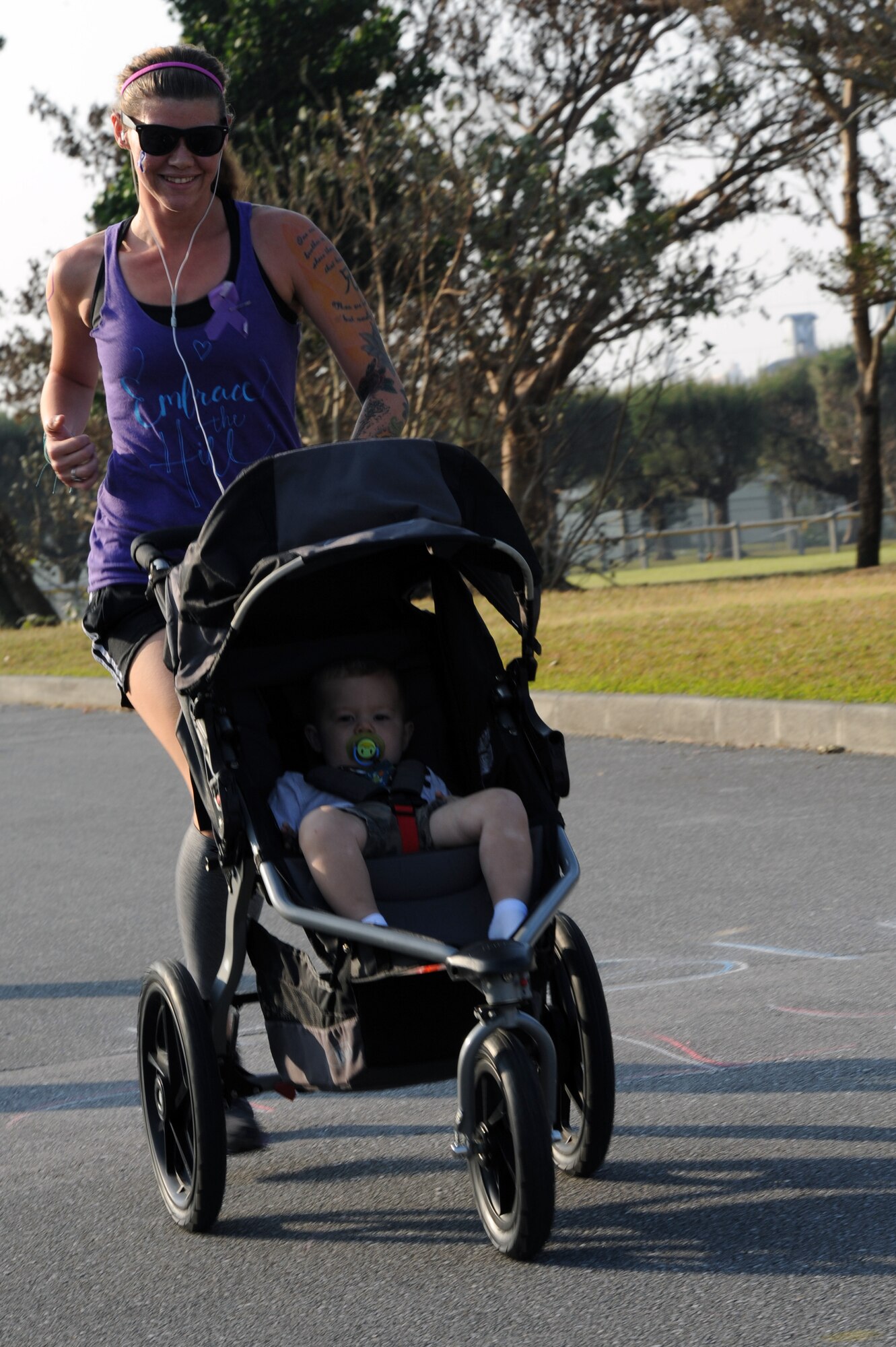 Abby Ackney, U.S. Marine Corps dependent, and her son, Arik, cross the halfway point during Kadena Family Advocacy's "Take a Stand Against Domestic Violence" 5K on Camp Lester, Japan, Oct. 25, 2014. Family Advocacy organized events throughout the month of October to promote awareness of domestic violence, including a flash mob and a joint-service masquerade gala. (U.S. Air Force photo by Airman 1st Class Zade C. Vadnais/Released)